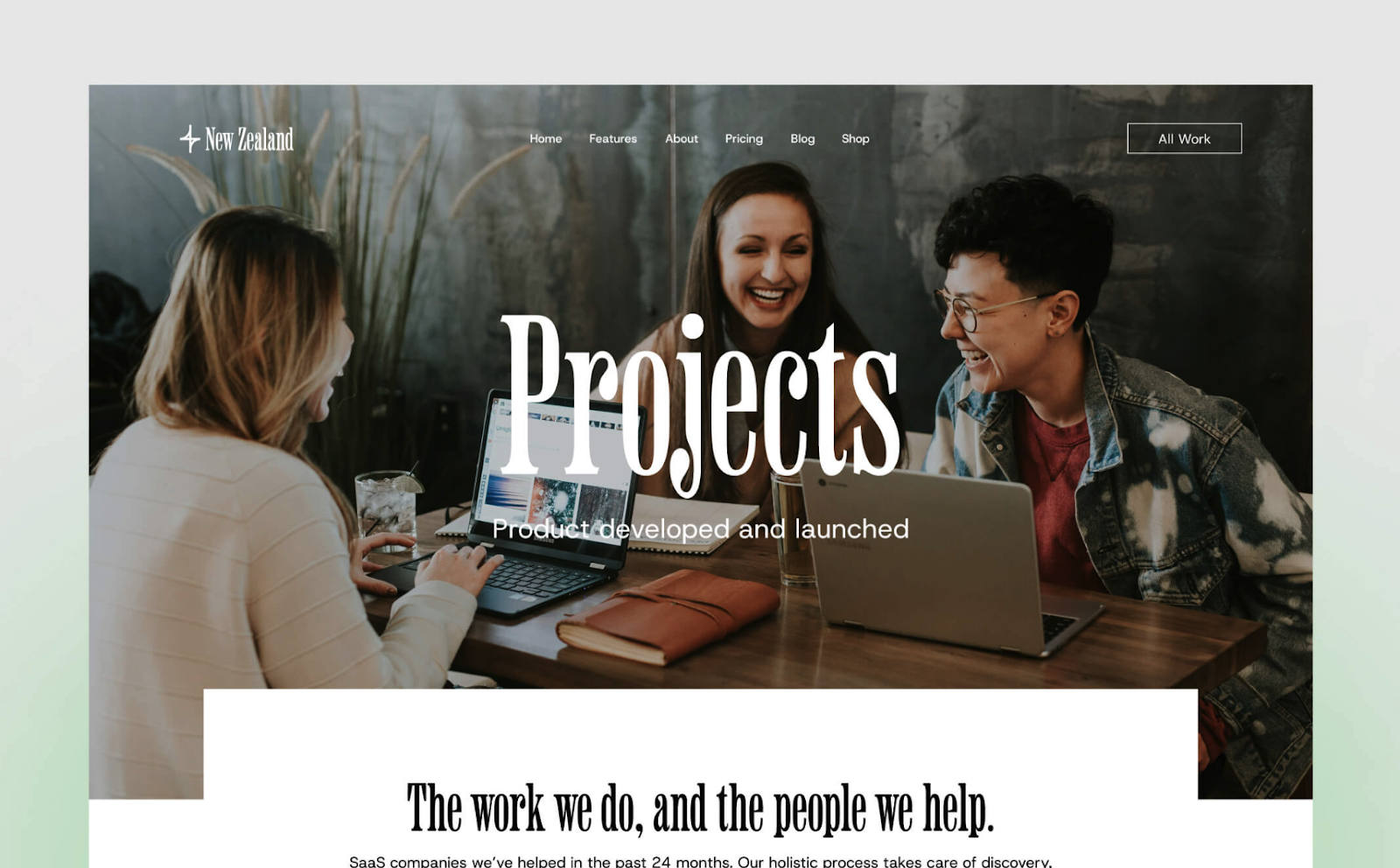 New Zealand Webflow Agency template showing three people collaborating around a laptop in a cozy office setting, smiling and interacting over a project on the template's home page.