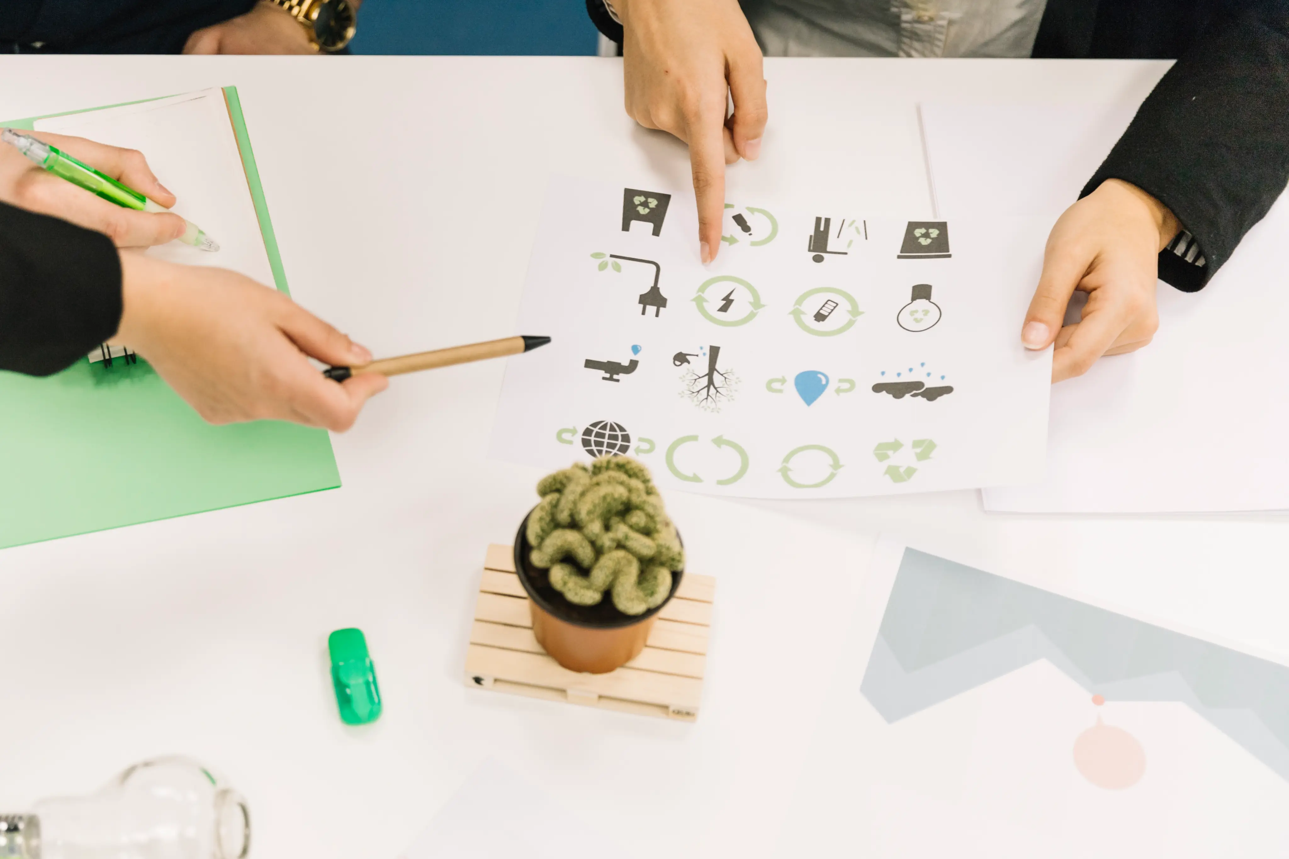 An image showng a person pointing at a letter with environmental design icons 