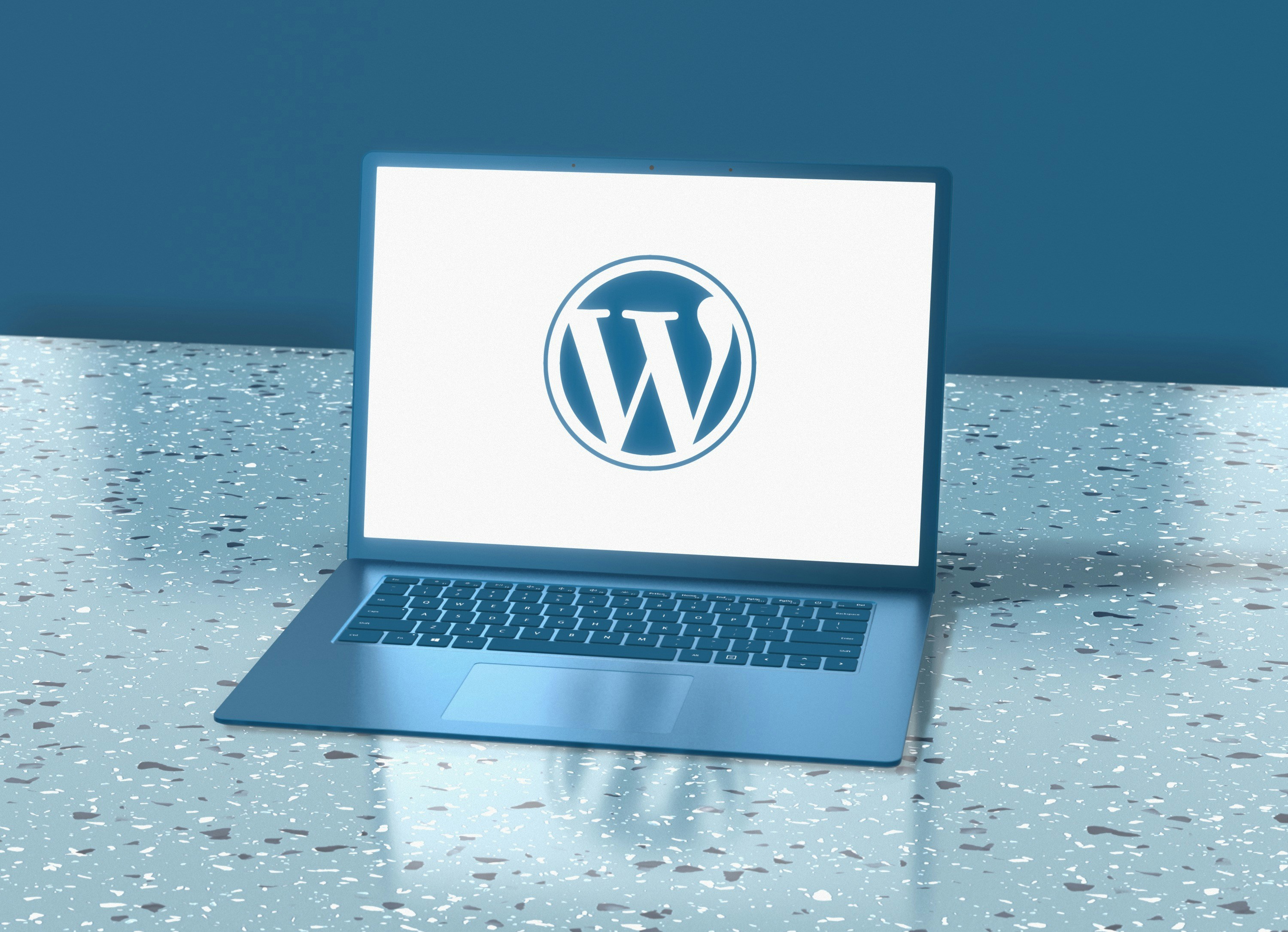 A picture of a macbook showcasing a large WordPress logo