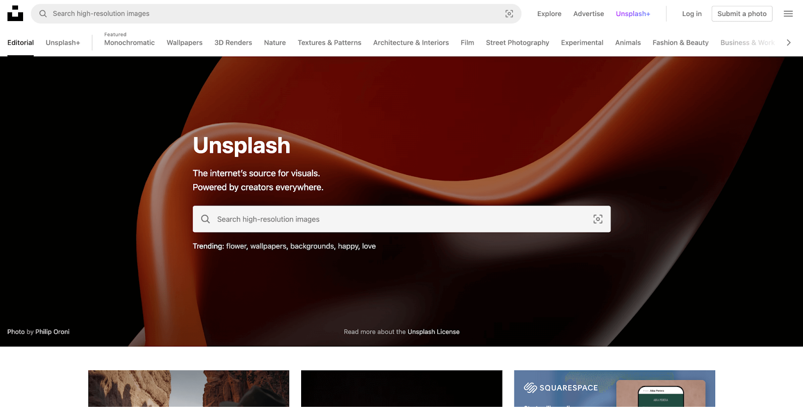 A screenshot of Unsplash's homepage showing a search bar and a brown background image